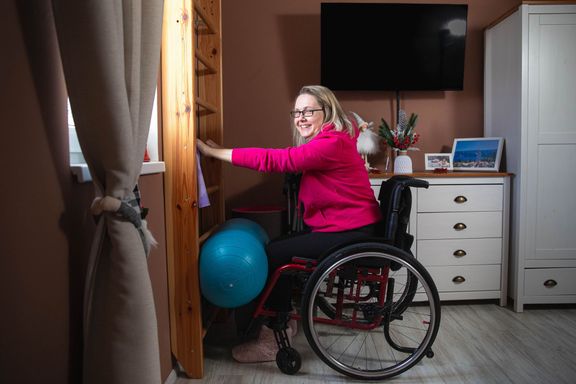 Michaela se z vozíku zvedá rukama pomocí žebřin.